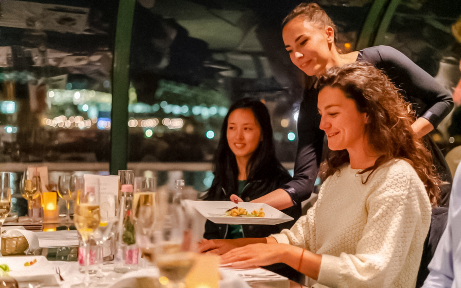 Server presenting dish during Budapest Danube River candlelit dinner cruise.