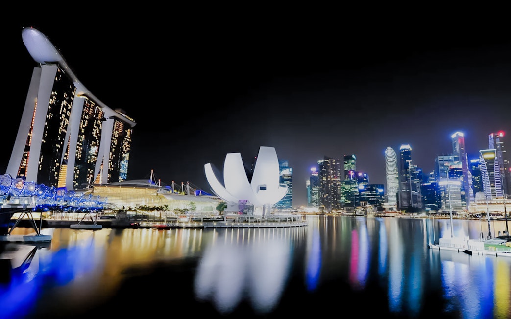 Marina Bay Sands and skyline at night during yacht cruise in Singapore.