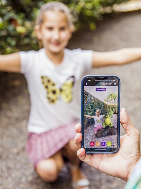 Child posing with arms outstretched at Amaze World, captured on a smartphone.