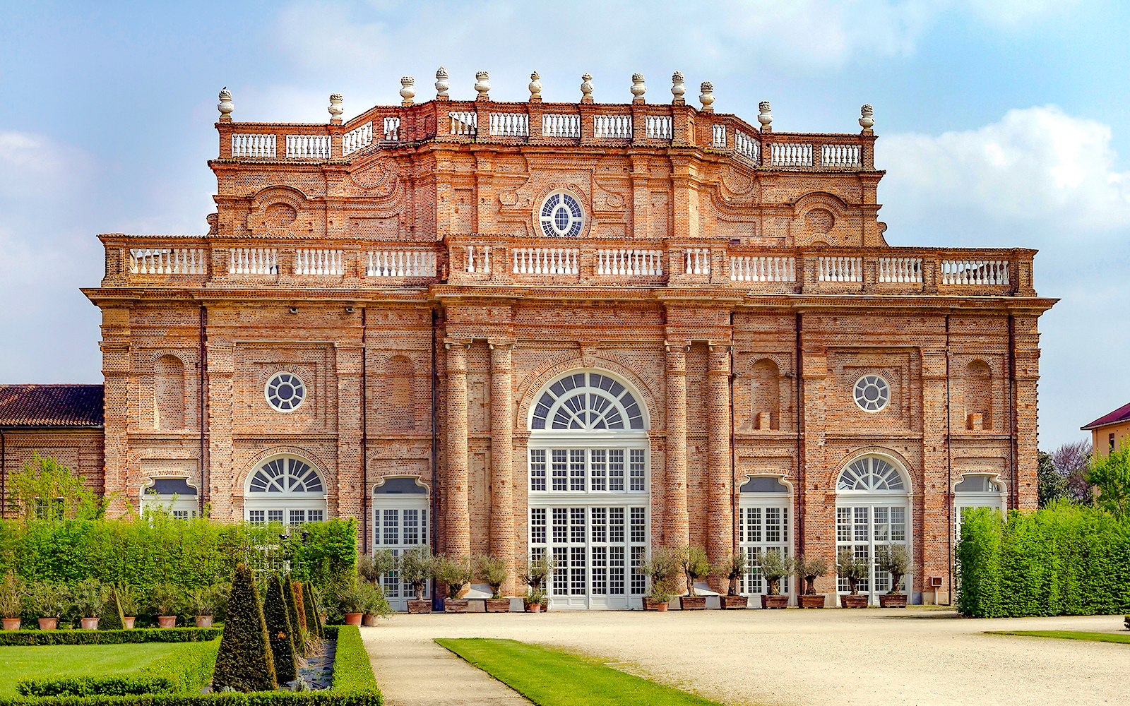 Savoy Royal Residence facade at La Venaria Reale, Turin, with manicured gardens.