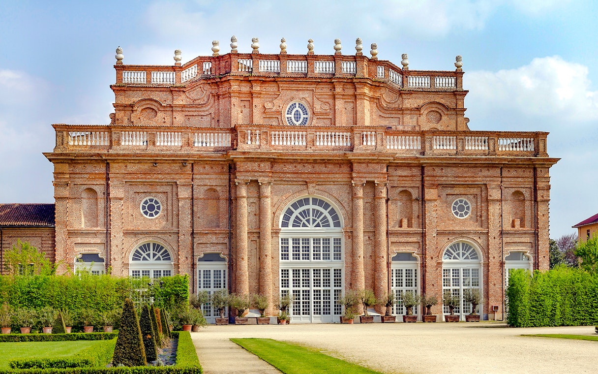 Savoy Royal Residence facade at La Venaria Reale, Turin, with manicured gardens.