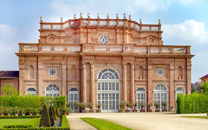Savoy Royal Residence facade at La Venaria Reale, Turin, with manicured gardens.