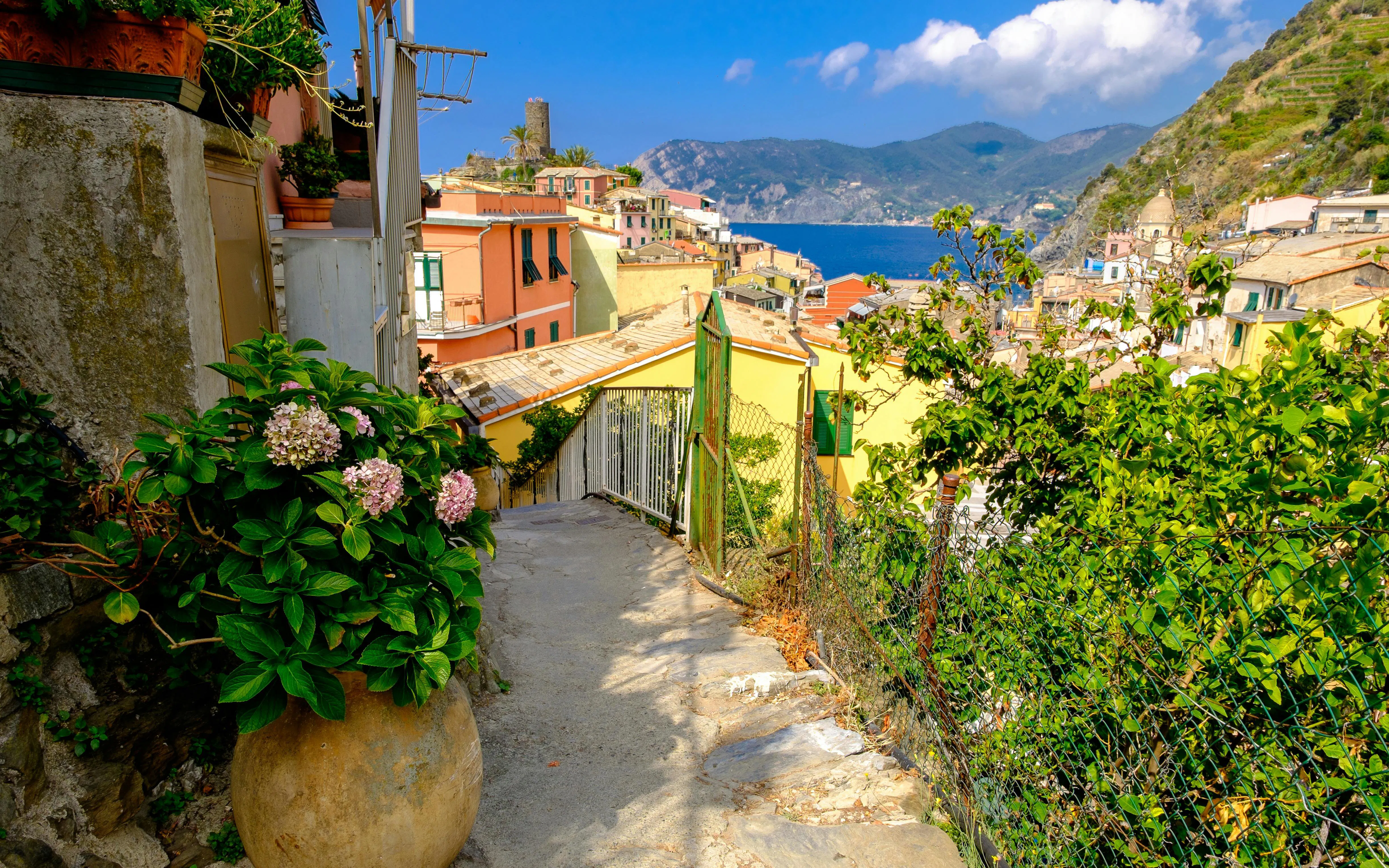 Hiking path view between Corniglia and Vernazza, Cinque Terre, with colorful houses and sea.