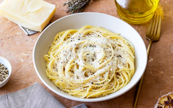 Roman spaghetti cacio e pepe with cheese and pepper in a white bowl.