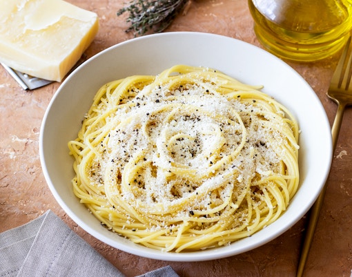 Roman spaghetti cacio e pepe with cheese and pepper in a white bowl.
