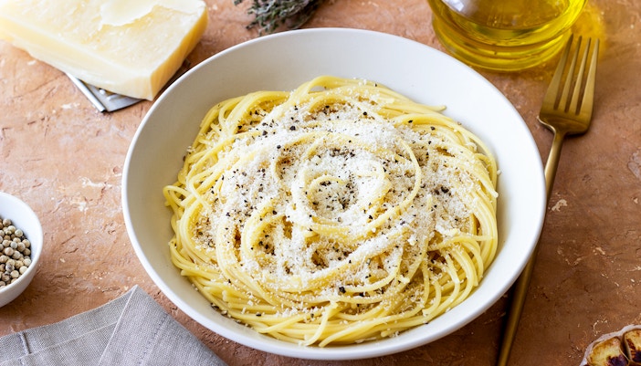 Roman spaghetti cacio e pepe with cheese and pepper in a white bowl.