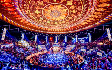 Rajadamnern Boxing Stadium interior with ornate ceiling and vibrant crowd.