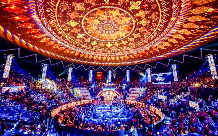 Rajadamnern Boxing Stadium interior with ornate ceiling and vibrant crowd.