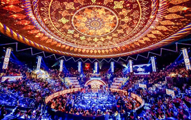 Rajadamnern Boxing Stadium interior with ornate ceiling and vibrant crowd.