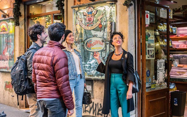 Tour group exploring a deli in Trastevere during a guided food and wine tour.