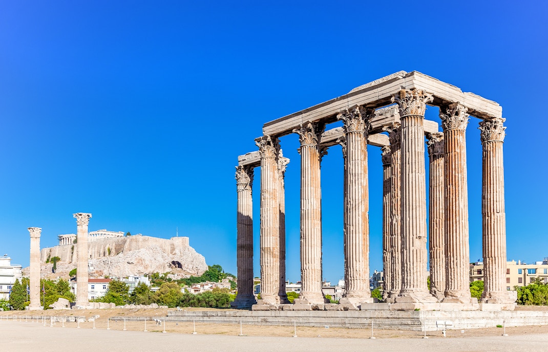 Temple of Olympian Zeus and world famous Acropolis hill with masterpiece Parthenon on top at the background, Athens historic centre, Attica, Greece