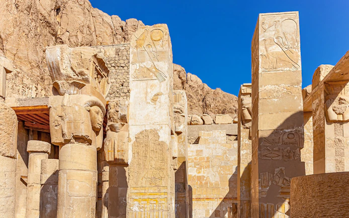 Hathor capital columns at Mortuary Temple of Hatshepsut, Luxor, Egypt, with hieroglyphs.