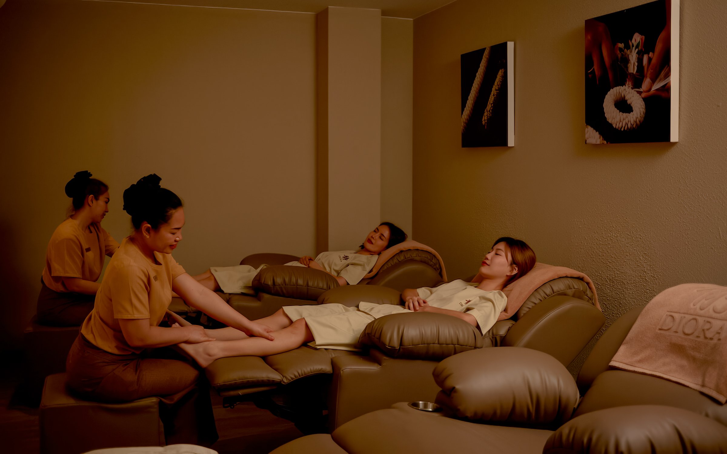 Thai massage with fresh herbal compress in a relaxing spa setting with comfortable sofas.