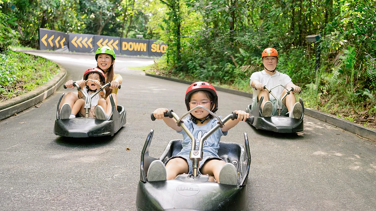 Family enjoying a ride on The Skyline Luge track in Kuala Lumpur.