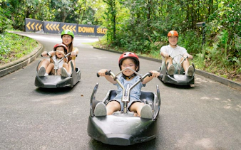 Family enjoying a ride on The Skyline Luge track in Kuala Lumpur.