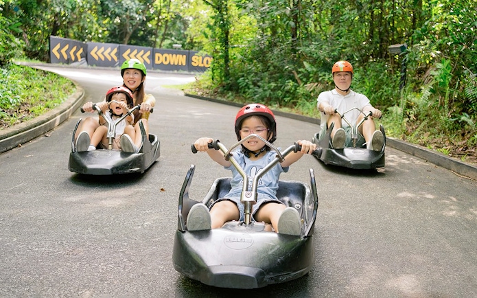 Family enjoying a ride on The Skyline Luge track in Kuala Lumpur.