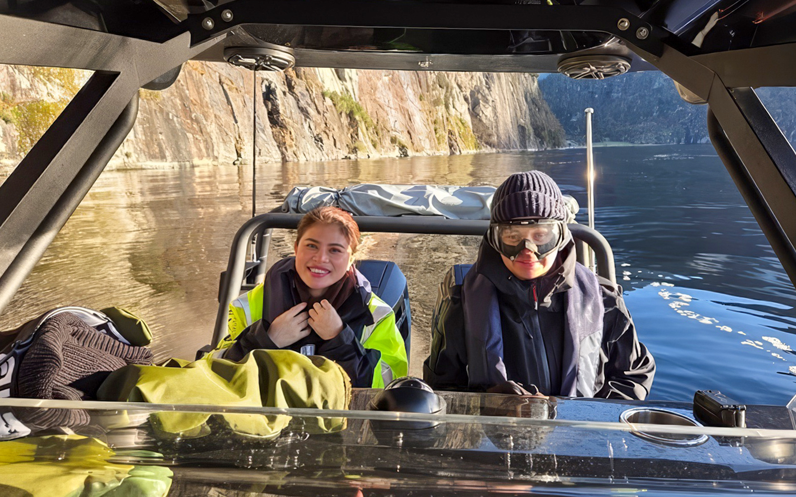 Guests on a RIB boat enjoying Alversund Fjord Safari with rocky cliffs in the background.