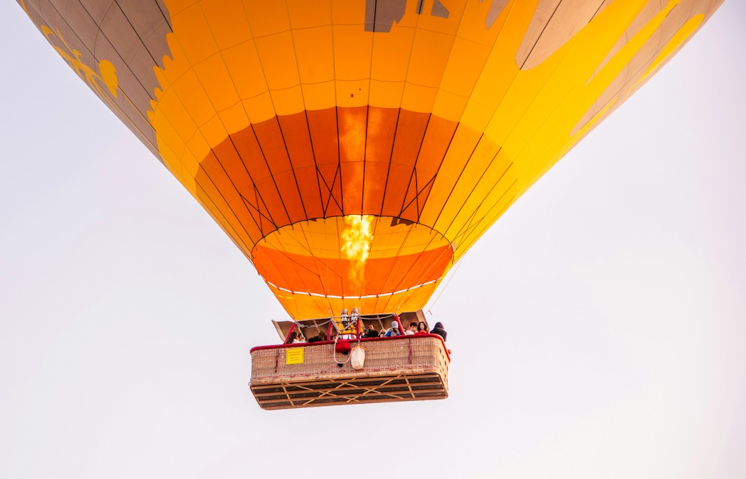VIP hot air balloon with passengers ascending over Marrakech.
