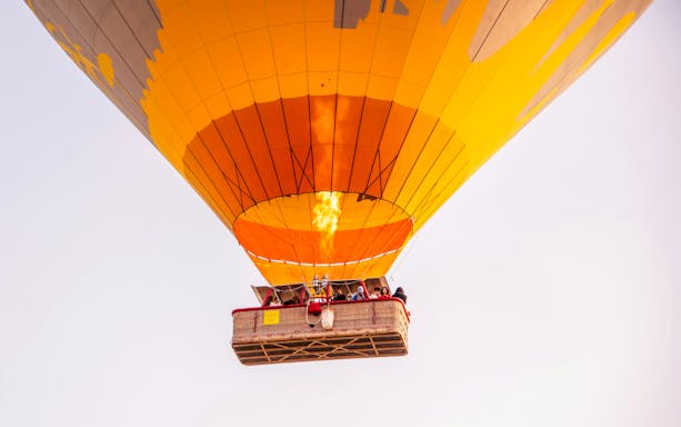 VIP hot air balloon with passengers ascending over Marrakech.