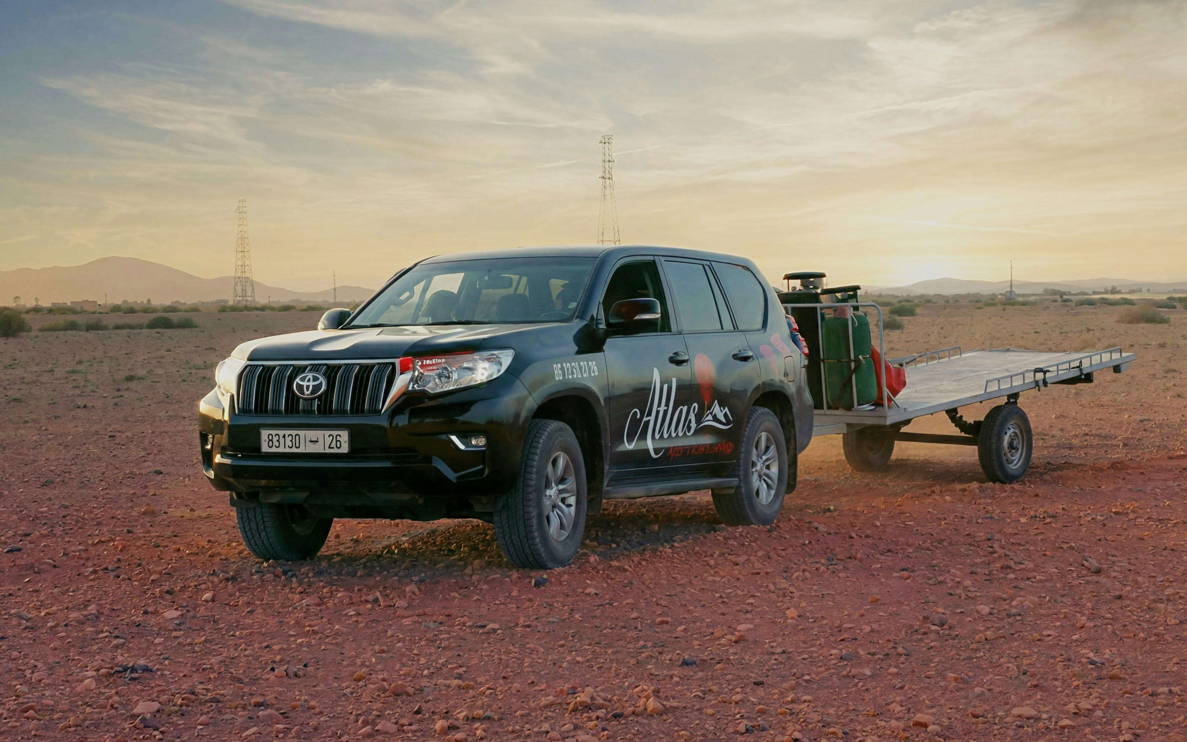 SUV with trailer on desert terrain at sunrise in Marrakech.