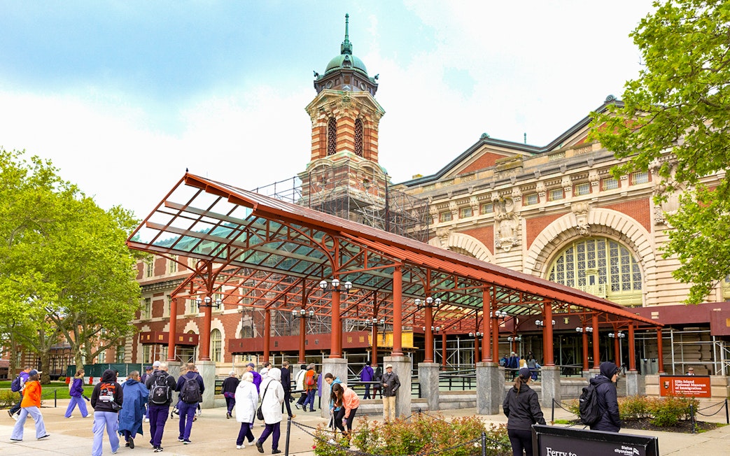 Ellis Island Immigration Museum entrance with visitors in New York City.