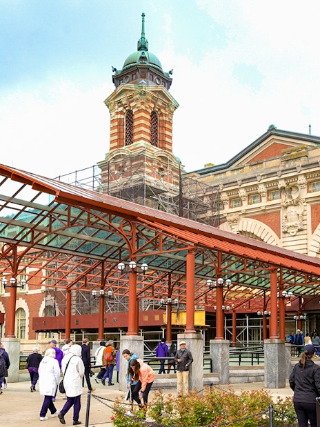 Ellis Island Immigration Museum entrance with visitors in New York City.