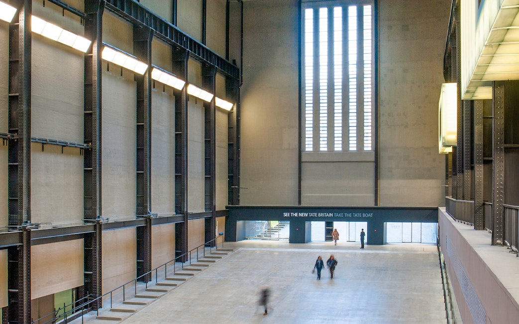 Tate Modern Turbine Hall interior with visitors walking through the large open space.