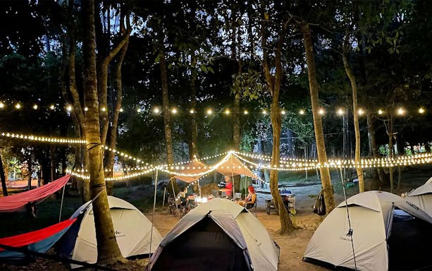 Tents and string lights in a forest setting at SKYTREX Adventure Sungai Congkak, Kuala Lumpur.