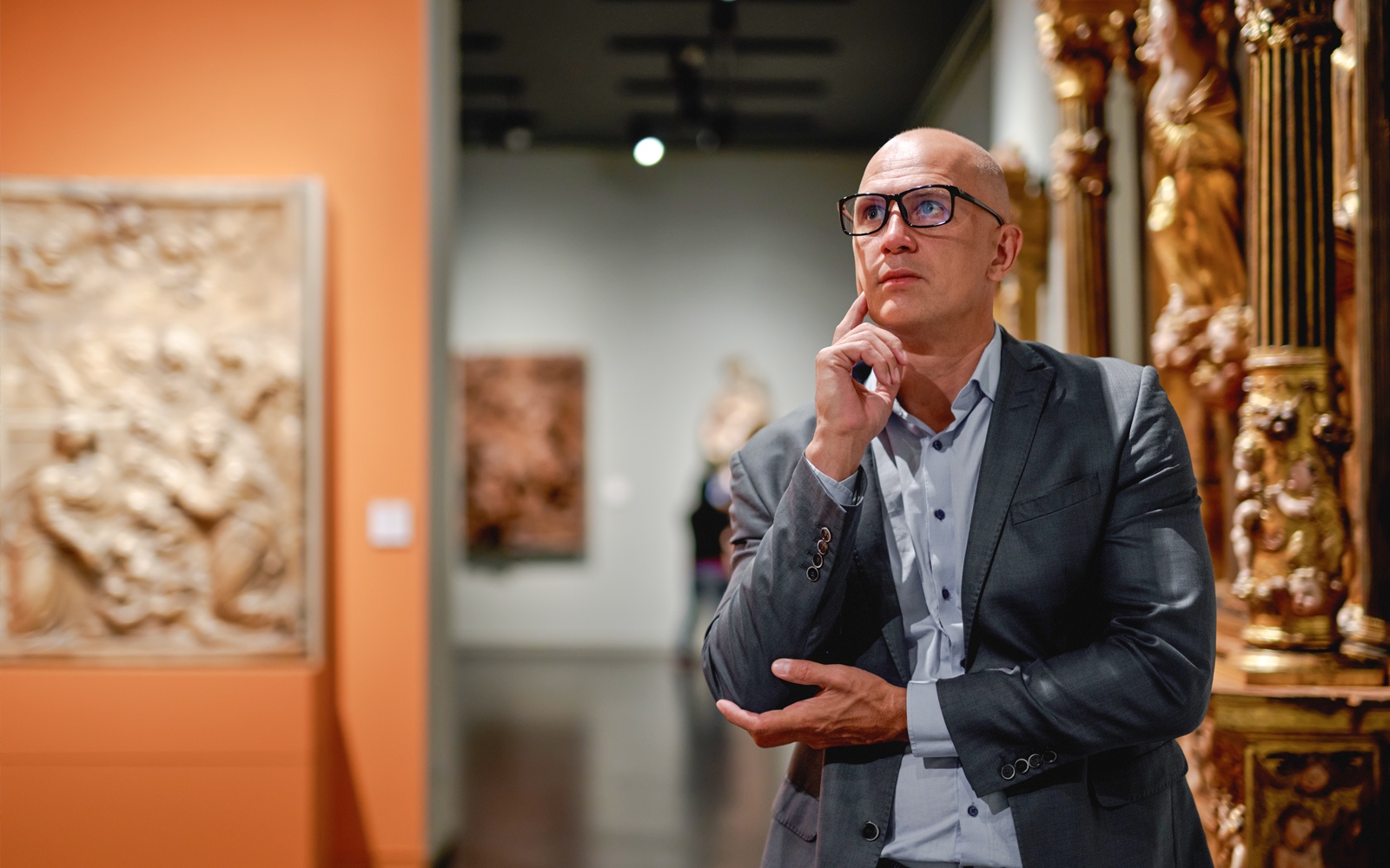 Man viewing paintings in an art gallery.