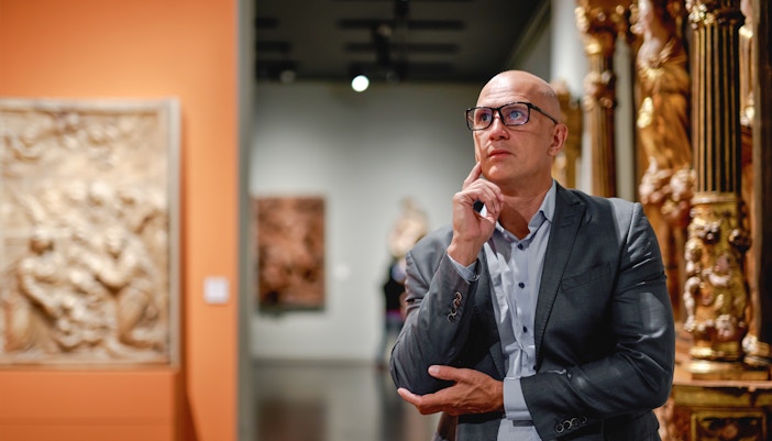 Man viewing paintings in an art gallery.