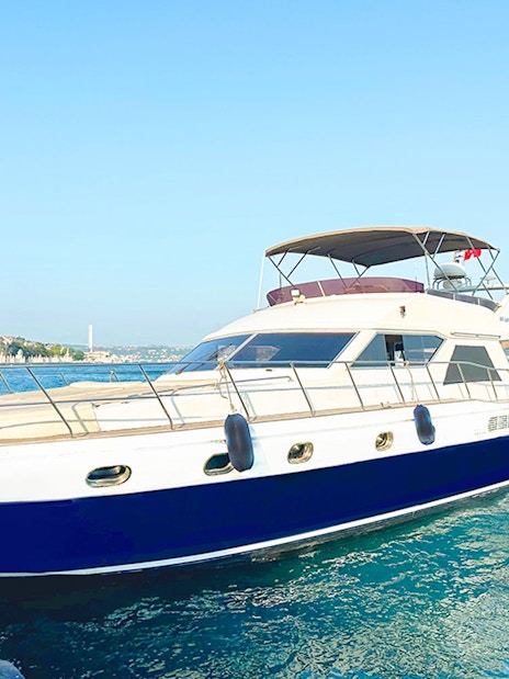 Yacht docked on the Bosphorus with cityscape in the background, Istanbul.