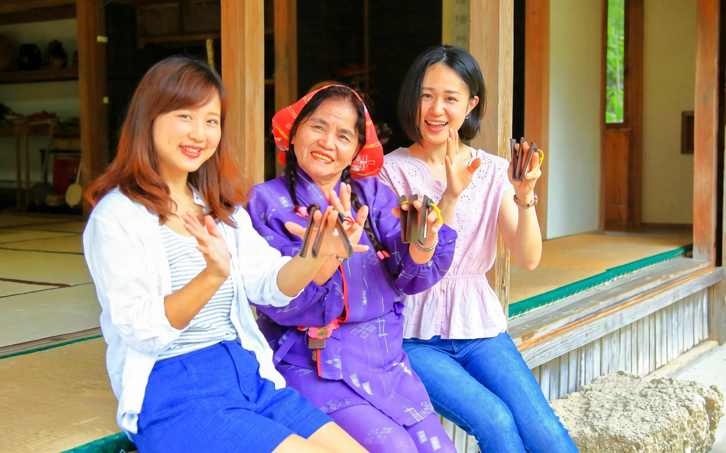 Women playing traditional instruments at Ishigaki Yaima Village, Japan.