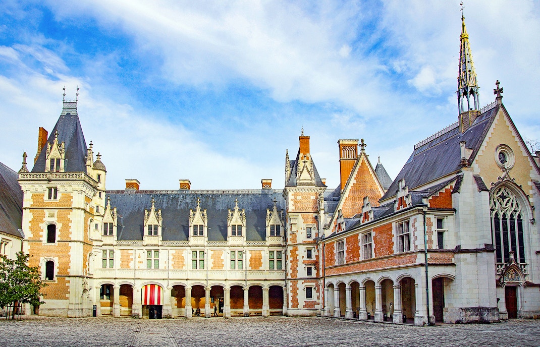 Royal Blois Castle exterior with intricate architecture and lush gardens, Blois, France.