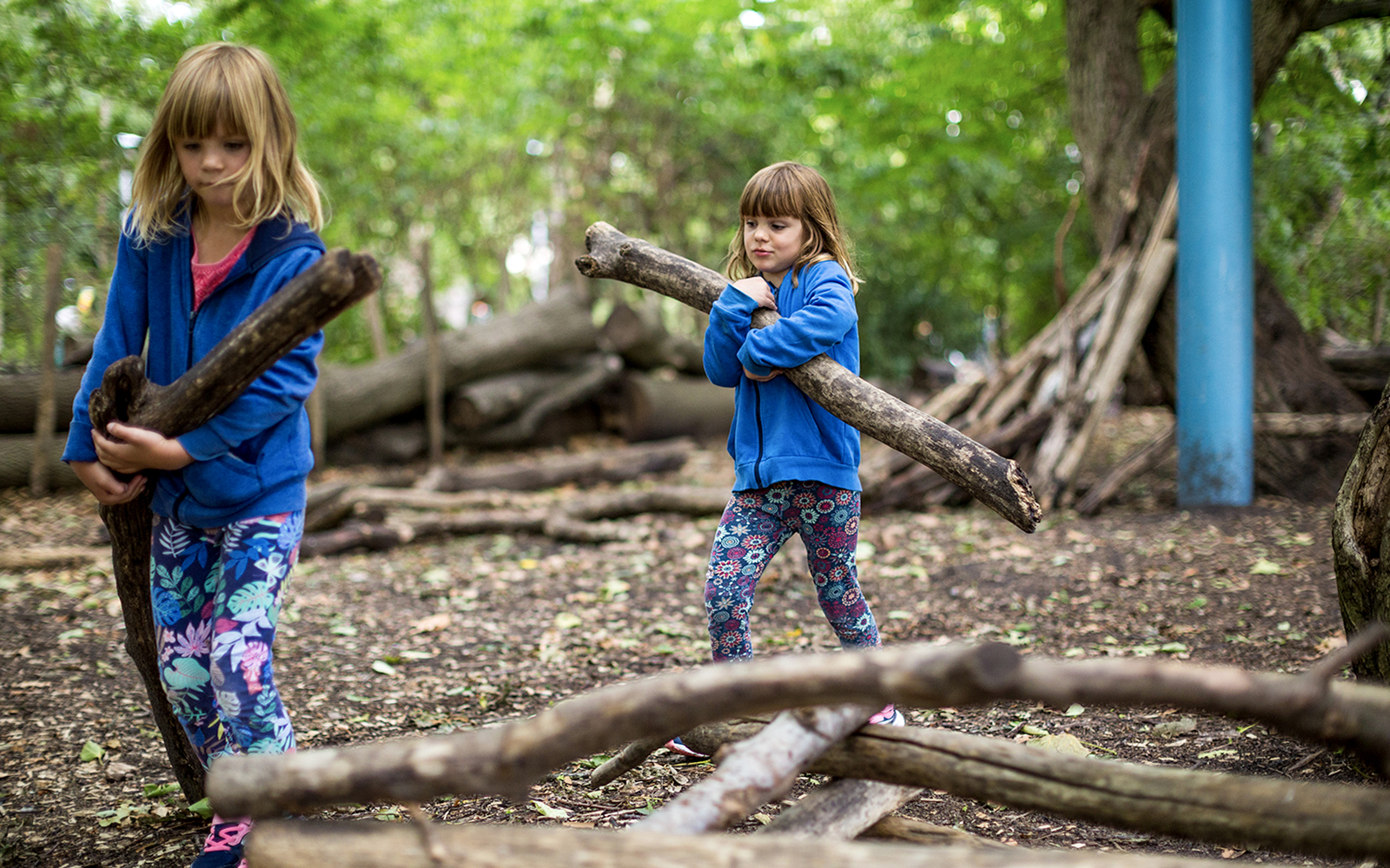 Children building forts with logs at Bronx Zoo.