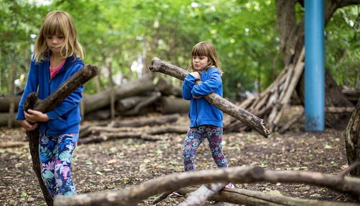 Children building forts with logs at Bronx Zoo.