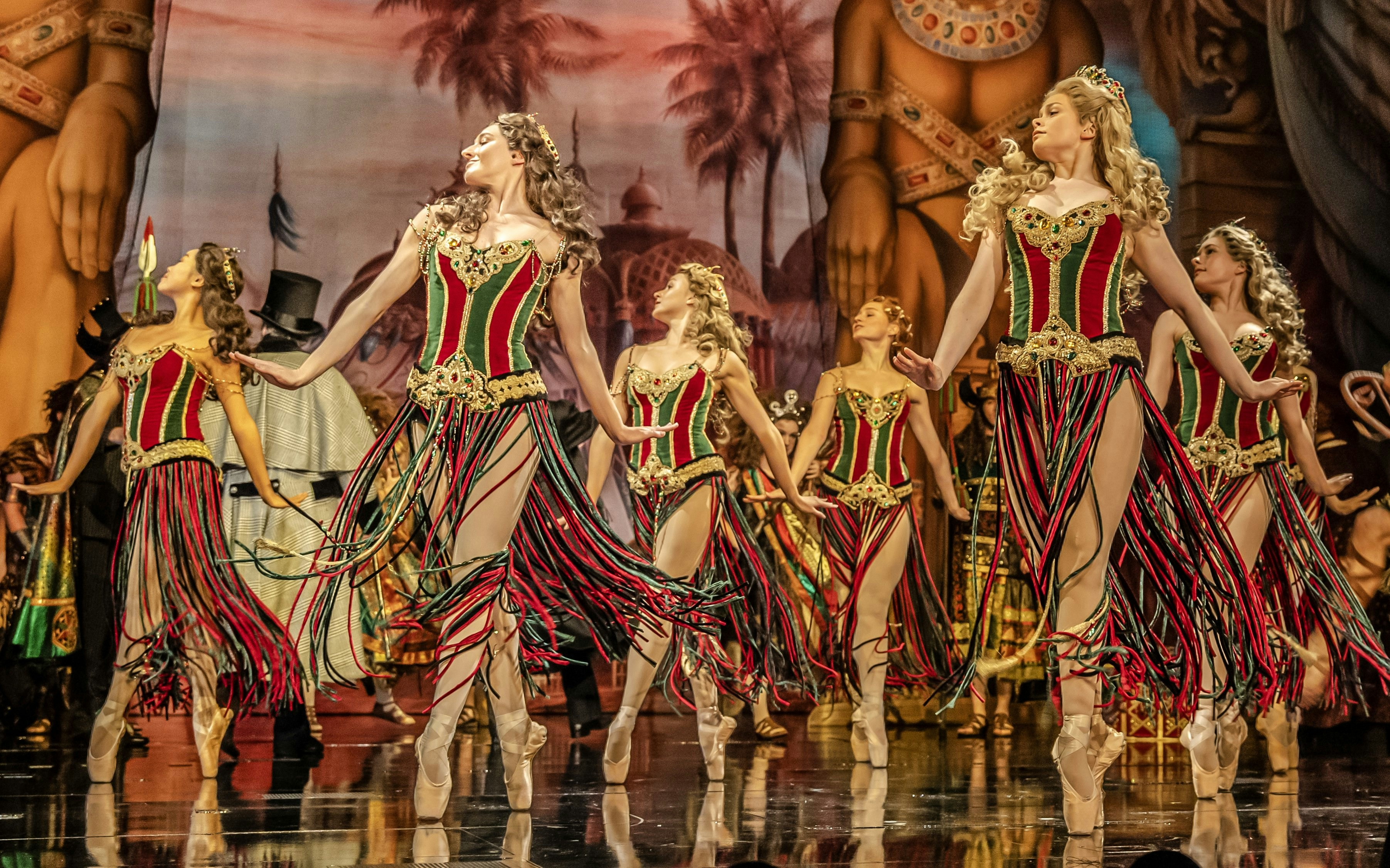 Dancers in colorful costumes perform on stage during Phantom of the Opera production.
