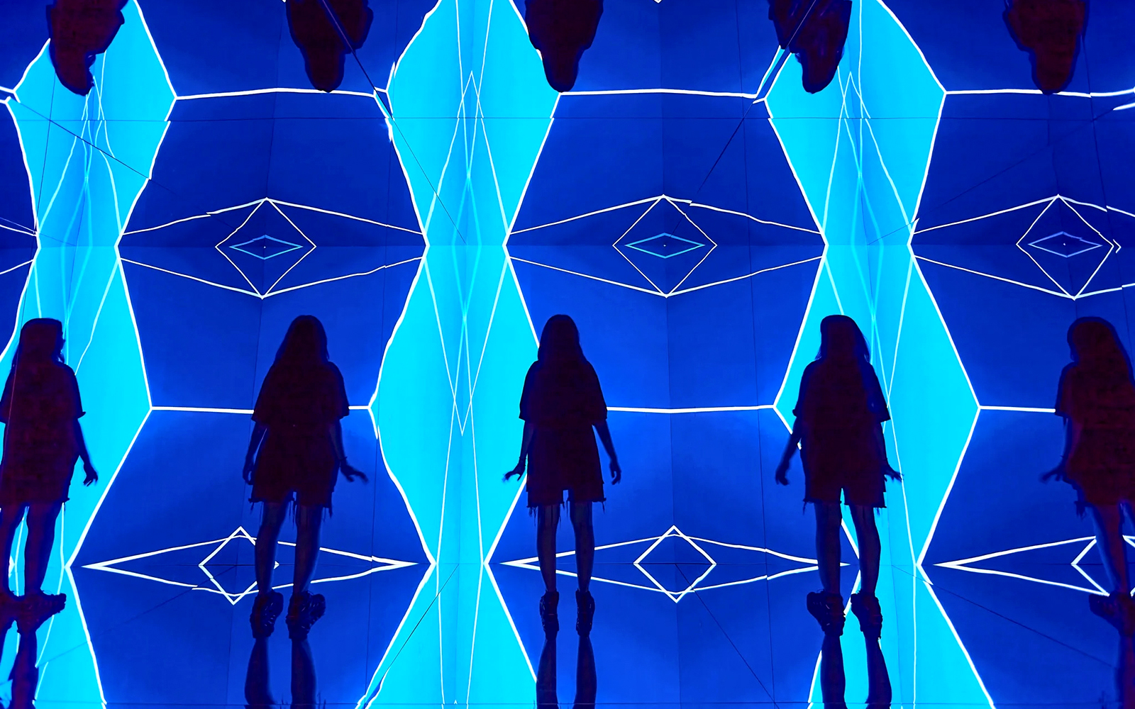 Guest exploring geometric light installation at Light Art Museum.