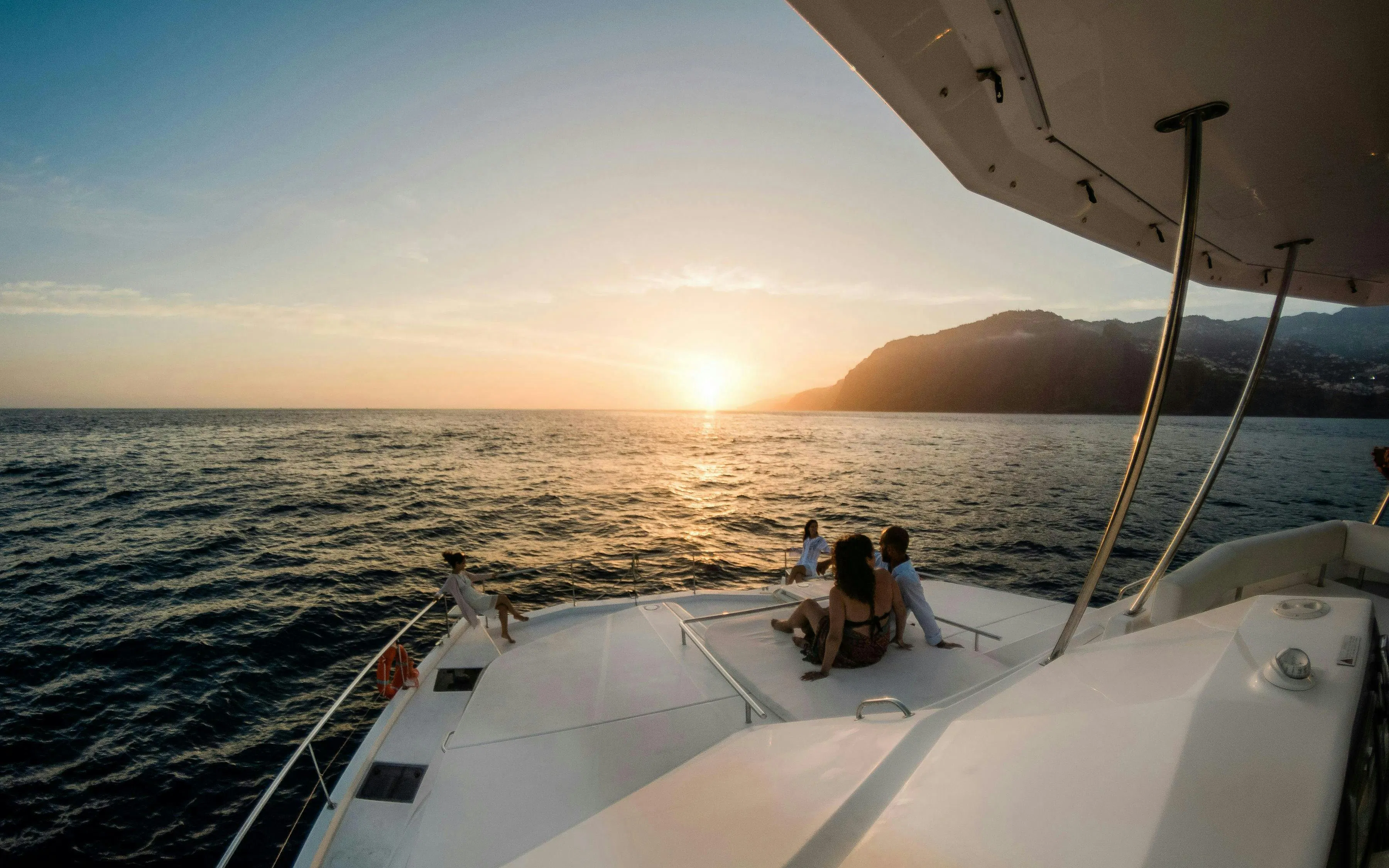 Small group enjoying sunset on a boat during dolphin and whale watching cruise.