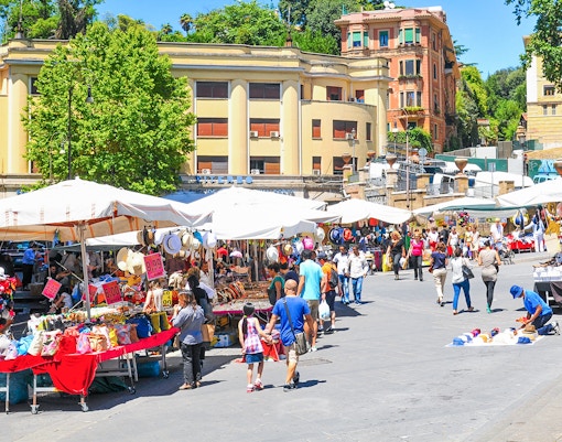 Outdoor market stalls with fresh produce and goods in Rome, Italy.