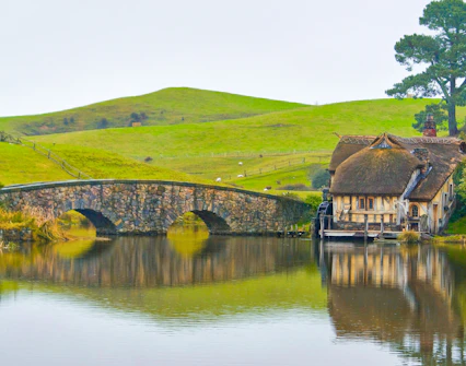 Double arched stone bridge and mill at Hobbiton Movie Set, Matamata, New Zealand.