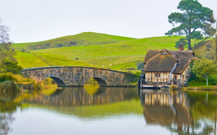 Double arched stone bridge and mill at Hobbiton Movie Set, Matamata, New Zealand.