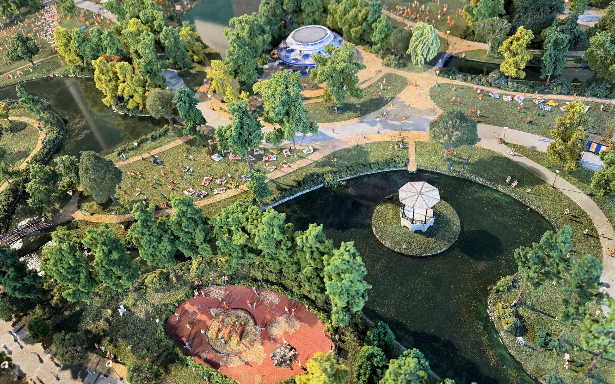 Aerial view of Vondelpark in Amsterdam with people relaxing on the grass and a pond with a gazebo.