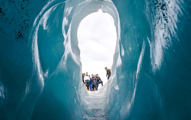 Guests hiking through an ice cave on Sólheimajökull glacier in Iceland.