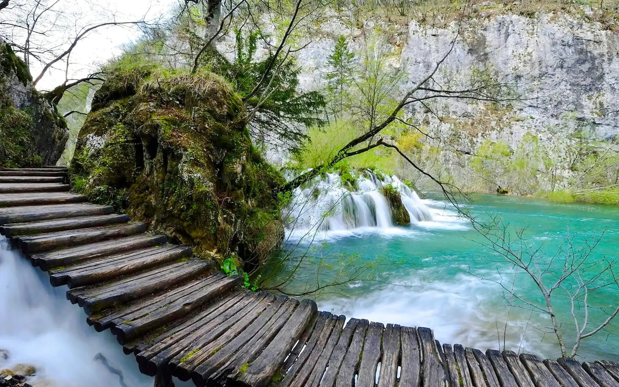 Wooden path over turquoise water and waterfalls at Plitvice Lakes, Croatia.