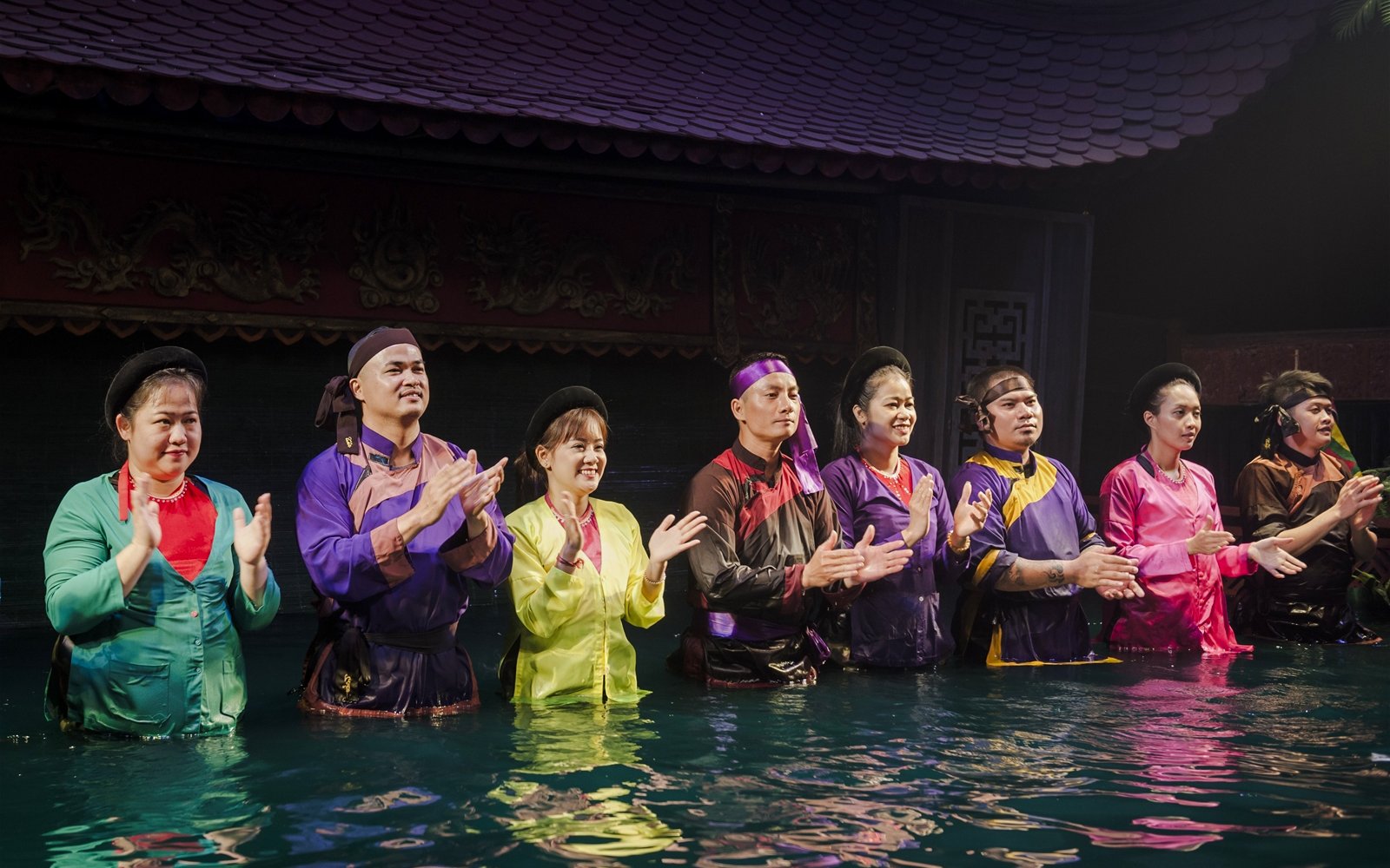 Performers clapping in water at Thang Long Water Puppet Show, Hanoi.