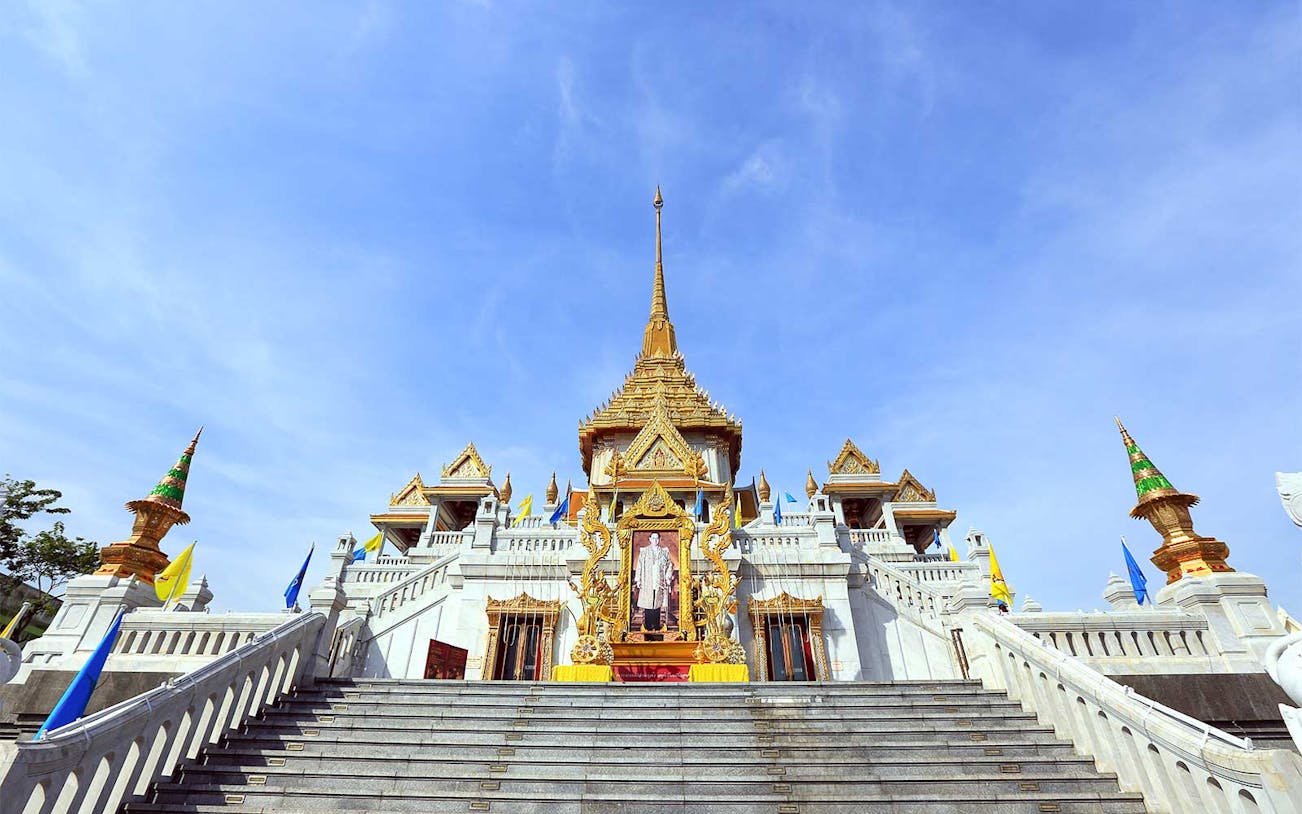 Wat Traimit temple in Bangkok with ornate golden spire and staircase.