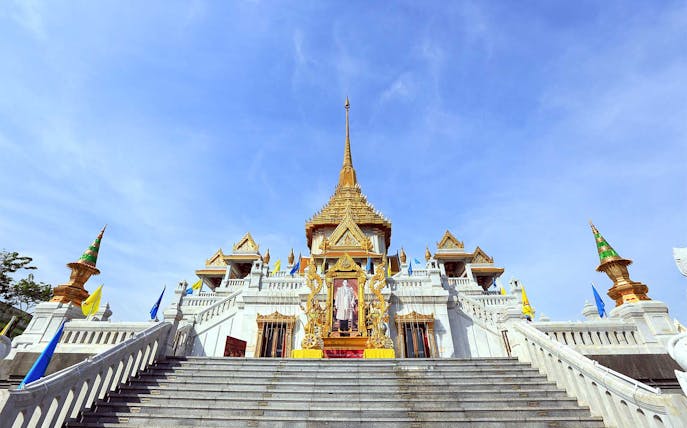 Wat Traimit temple in Bangkok with ornate golden spire and staircase.
