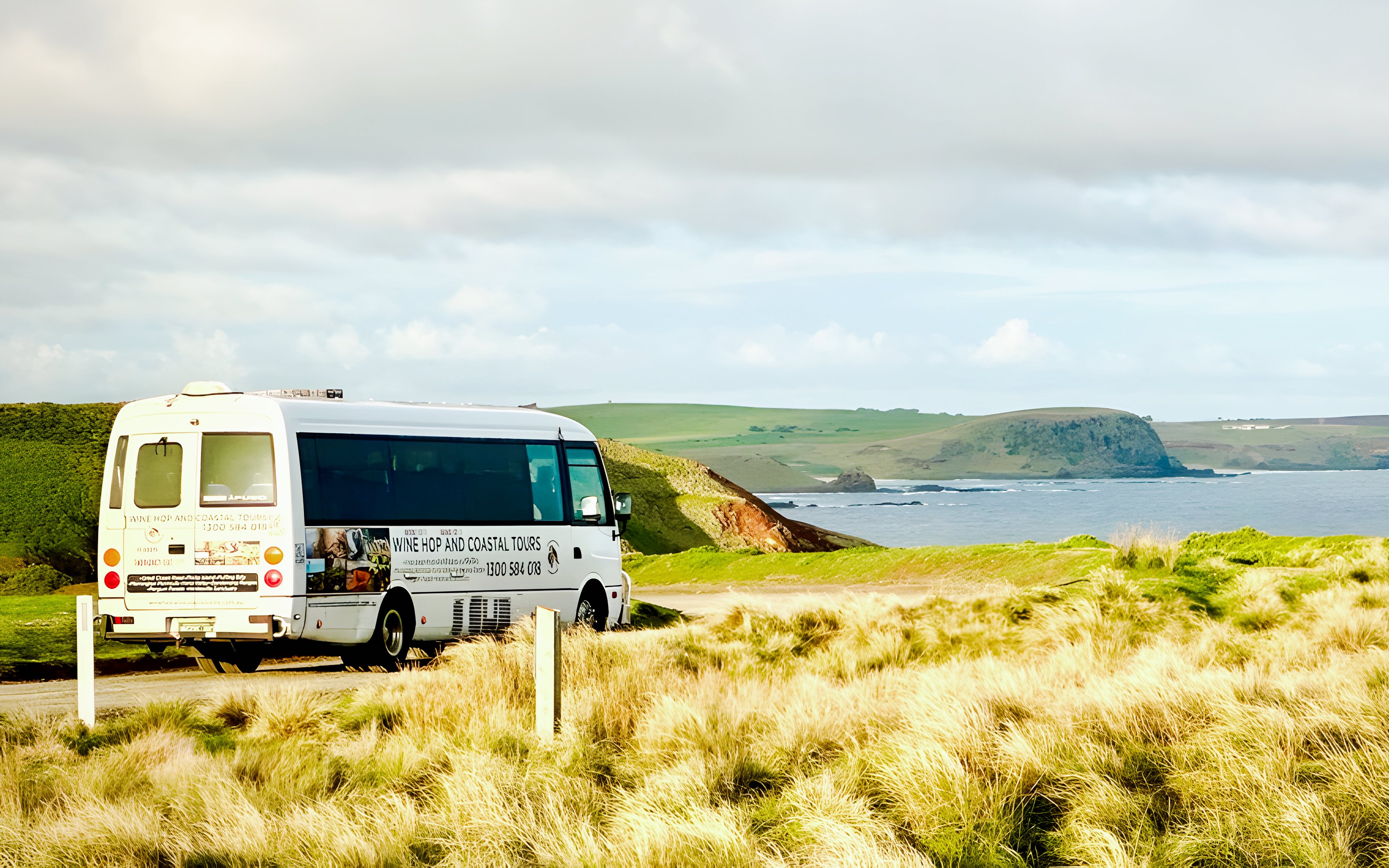 Tour bus on a scenic coastal road at Phillip Island, Australia.