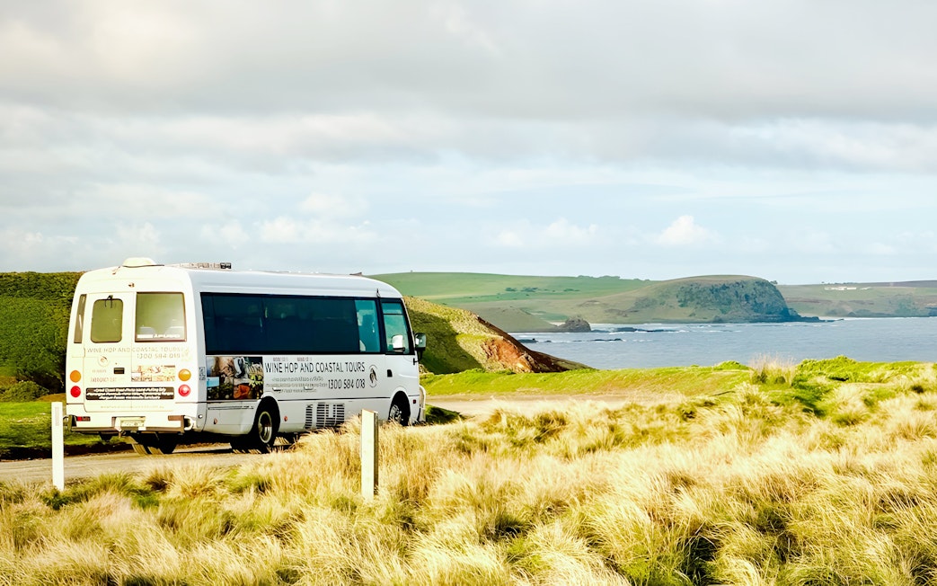 Tour bus on a scenic coastal road at Phillip Island, Australia.