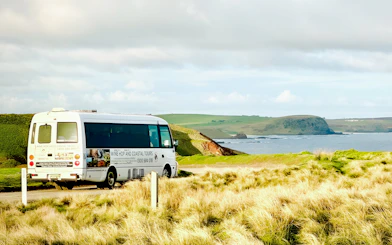 Tour bus on a scenic coastal road at Phillip Island, Australia.